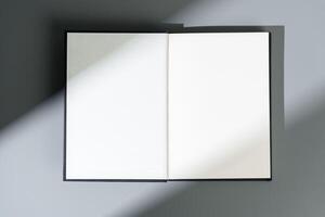 Blank open notepad on gray background studio shot photo