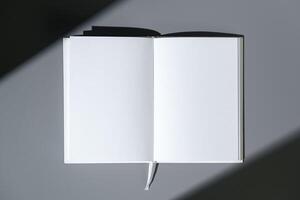 Blank open notepad on gray background studio shot photo
