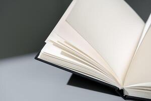 Blank open notepad on gray background studio shot photo