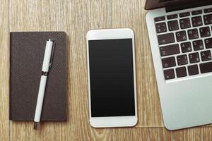 Office table with smartphone on it. View from above photo
