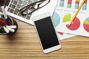 Office table with smartphone on it. View from above photo