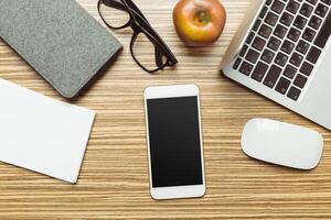 Office table with smartphone on it. View from above photo