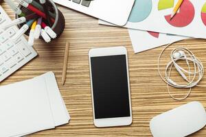 Office table with smartphone on it. View from above photo