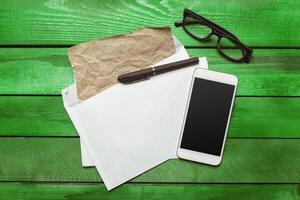 Office table with smartphone on it. View from above photo