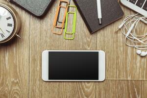 Office table with smartphone on it. View from above photo