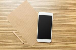 Office table with smartphone on it. View from above photo