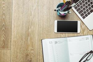 Office table with smartphone on it. View from above photo