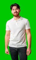 Young man with a beard smiling while standing against a bright green background photo