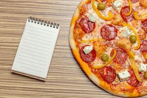 Pizza with blank paper with copy space photo
