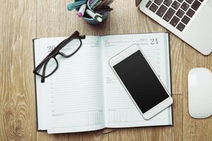 Office table with smartphone on it. View from above photo