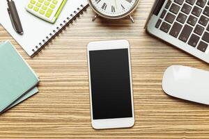 Office table with smartphone on it. View from above photo