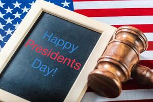 the text happy presidents day written in a chalkboard and a flag of the United States photo