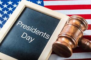 the text happy presidents day written in a chalkboard and a flag of the United States photo