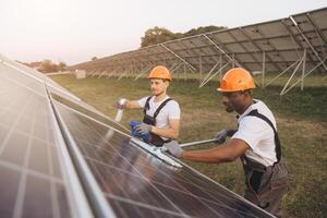 Workers Cleaning Solar Panels at a Solar Farm During Sunset photo