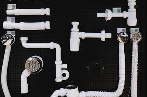 many different white plastic bath drain systems on store display photo