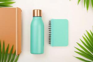 A flat lay of eco-friendly products showcasing a reusable water bottle and notebooks on a light background photo