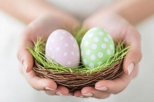 Brightly colored Easter eggs in a wicker nest held in hands, celebrating a joyful holiday moment photo