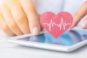 Doctor examines ECG data on tablet in a bright clinical setting showcasing modern healthcare technology photo
