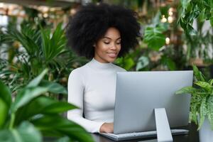 Young woman programming in a modern tech startup office filled with plants and soft lighting photo