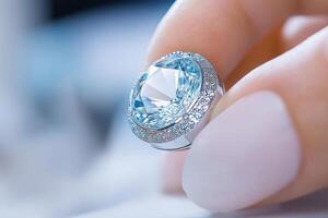 Jeweler working at a bench, examining a sparkling blue gemstone with magnifying tools in a bright workshop photo