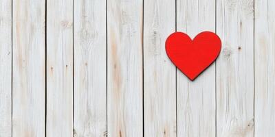 Single red heart rests on a weathered wooden fence symbolizing love and solitude in a minimalistic setting photo