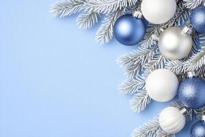 Delicate Christmas frame with frosty pine branches and silver blue ornaments on a soft blue background photo