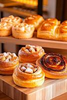 Freshly baked pastries arranged on rustic wooden platters in a warm bakery with inviting golden lighting photo