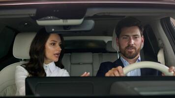 Woman female girl consultant trader talking consult client buyer sitting together in salon of new car automobile choosing vehicle in showroom man businessman guy business male buying auto test drive video