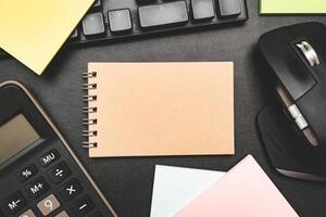 Top view of notebook. Blank paper notepad on office desk table with keyboard and other supplies. Blank notebook page for input the text. copy space, flat lay. photo