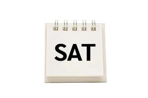SAT text on desk calendar with clipping path isolated on white background. SATURDAY and Calendar concept photo