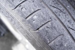 Close up of car tire tread deterioration from use , worn out a car tire , Car maintenance concept photo