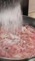 agregando azúcar a un caramelizado cebolla mientras fritura video