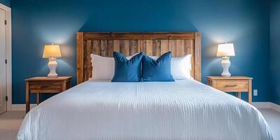 This tranquil bedroom features a luxurious white bed against elegant teal walls, with a rustic headboard, stylish lamps, and minimalistic decor, creating an ideal haven for relaxation photo
