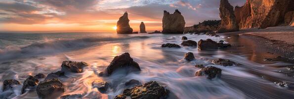 Witness an aweinspiring sunset on a rocky shore amidst striking formations and gentle waves under a colorful sky photo