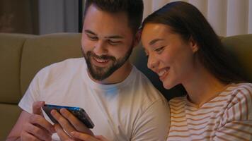 caucásico Pareja hombre mujer novio Novia juntos cama dormitorio móvil teléfono teléfono inteligente artilugio riendo sonriente acecho gracioso tecnología disfrutar humor hojeada hembra masculino novio esposos foto