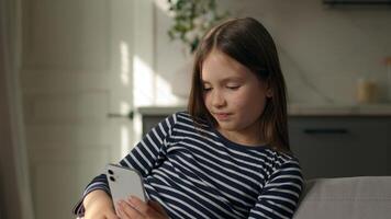 caucásico pequeño niña participación móvil teléfono teléfono inteligente desplazamiento acecho Internet en línea la risa humor red navegador sitio web gracioso niño hija niño sonriente alegría tecnología social medios de comunicación hogar foto