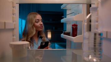 Point of view POV inside refrigerator Caucasian girl hungry woman open fridge at home kitchen look at empty shelves order food products delivery with mobile phone app online service web store shopping photo