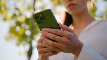 Close-up woman using mobile phone outdoors browsing social network checking email sending electronic sms message on smartphone making order in online shop booking in Internet cellphone new application photo