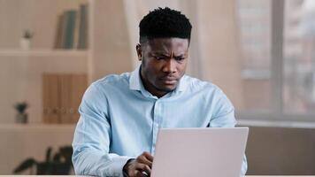 Angry guy annoyed african american man male boss worker dissatisfied has problem with computer system work feels wrath aggression with unsuccessful business deal slow internet read bad news data loss photo