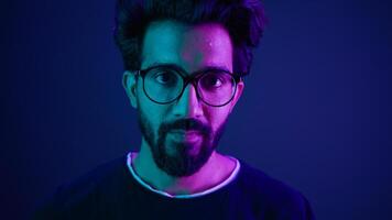 Close up portrait Arabian Indian man guy male programmer coder put on glasses 3d dimension focus gesture insight good eye sight vision focused view eyesight computer work in violet neon background photo