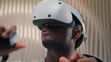 3d world gaming African American man male guy using controllers VR helmet virtual augmented reality glasses high-tech Internet technology futurism cyber game interface playing innovation metaverse photo