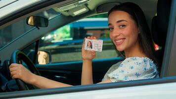 Happy glad positive Caucasian smiling woman female driver car owner auto buyer client sitting inside automobile looking at camera showing digital driving license passed exam drive courses rent vehicle photo