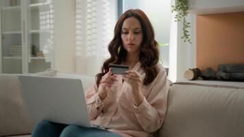 Caucasian girl has problem difficulties with internet bank irritated woman angry female at home hold credit card use laptop computer app try to pay online invalid number error unsuccessful transaction photo