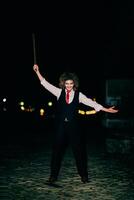 A mysterious figure, disguised as an assassin in a suit with wild hair, wields a menacing axe, embodying the very essence of fear and danger photo