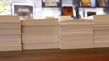 There are Stacks of Beautiful Blank Booklets Neatly Arranged on a Wooden Shelf in a Cozy Bookstore video