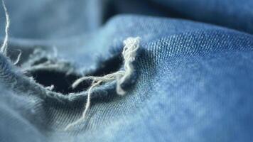 blue jean texture with a hole and ripped threads showing video