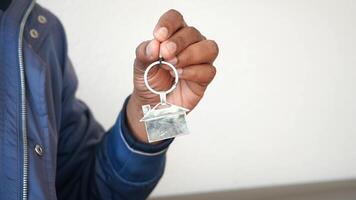 A Hand Firmly Gripping a Stylish Keychain Featuring a Clear and Transparent Model of a House Design video
