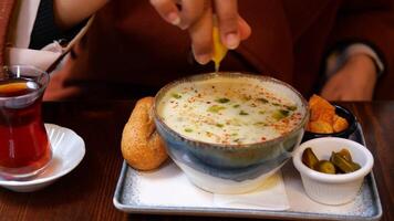 Squeezing a Fresh Lemon into a Bowl of Delicious Soup for Enhanced Flavor and Freshness video