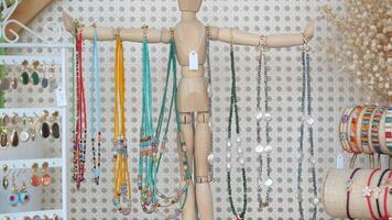 A Beautiful Array of Colorful, Unique Jewelry on a Rustic Wooden Mannequin Stand video