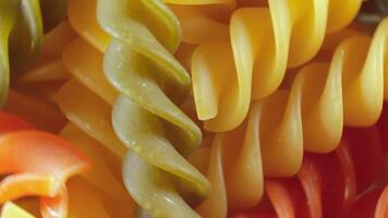 Uncooked Vibrant Colored Fusilli Pasta. A Mesmerizing Culinary Canvas of Multicolored Spirals, Textured Background - Rotating. Turning Colored Dry Pasta. Raw Macaroni - Rotating video